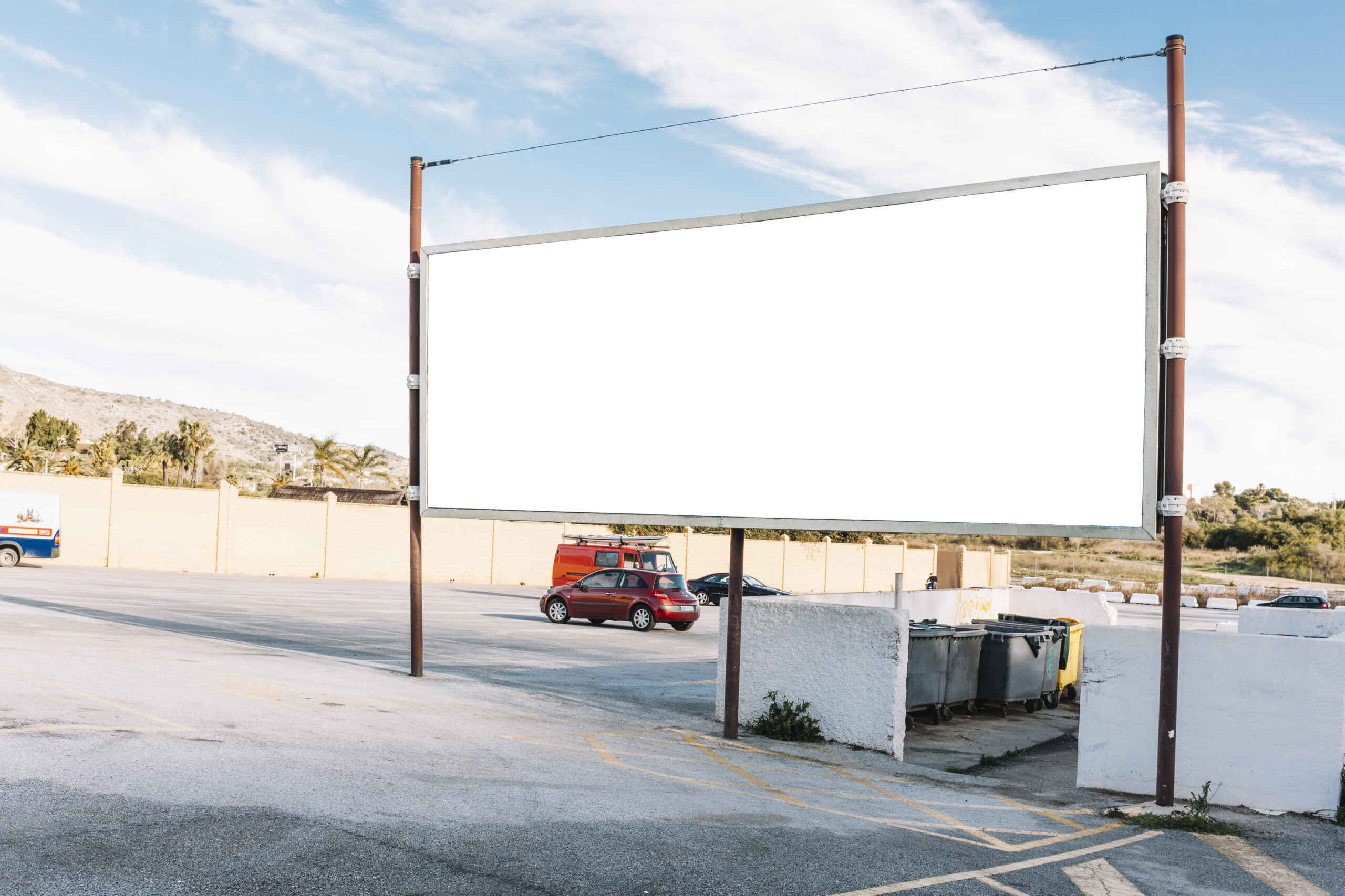 Valla publicitaria en blanco en una calle de Asturias con aparcamientos, ideal para campañas de Publicidad Digital en Asturias