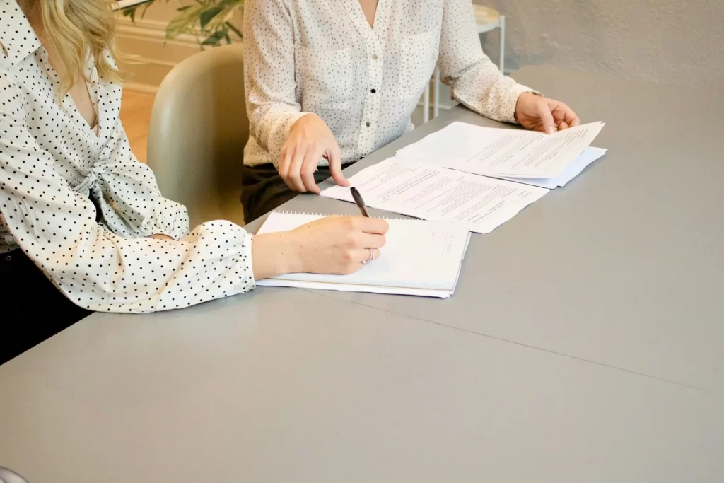 Dos personas revisan documentos en una reunión para elegir agencia de marketing digital